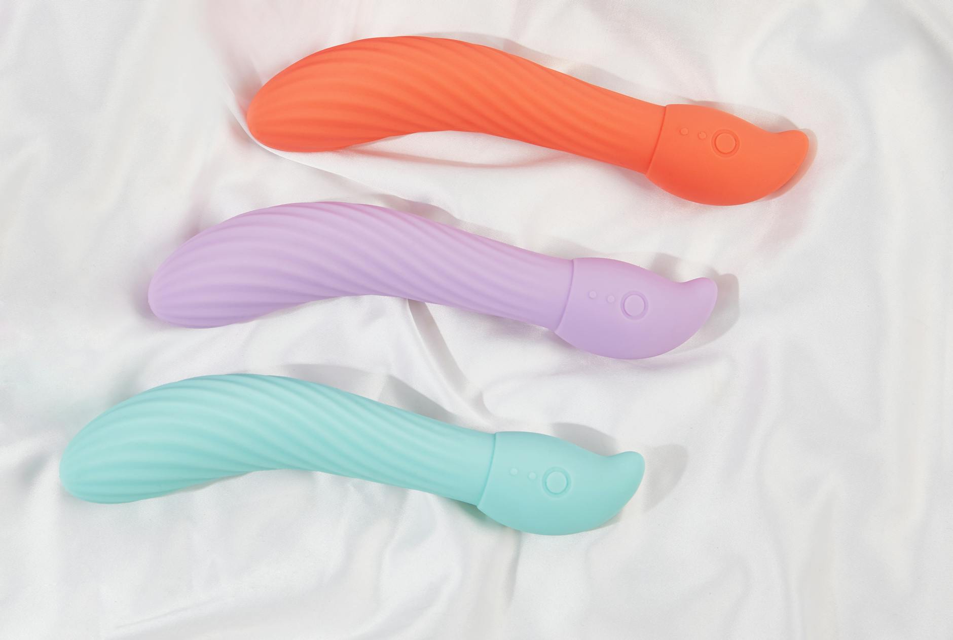 Close-up of vibrators on white fabric, highlighting their smooth texture and design.