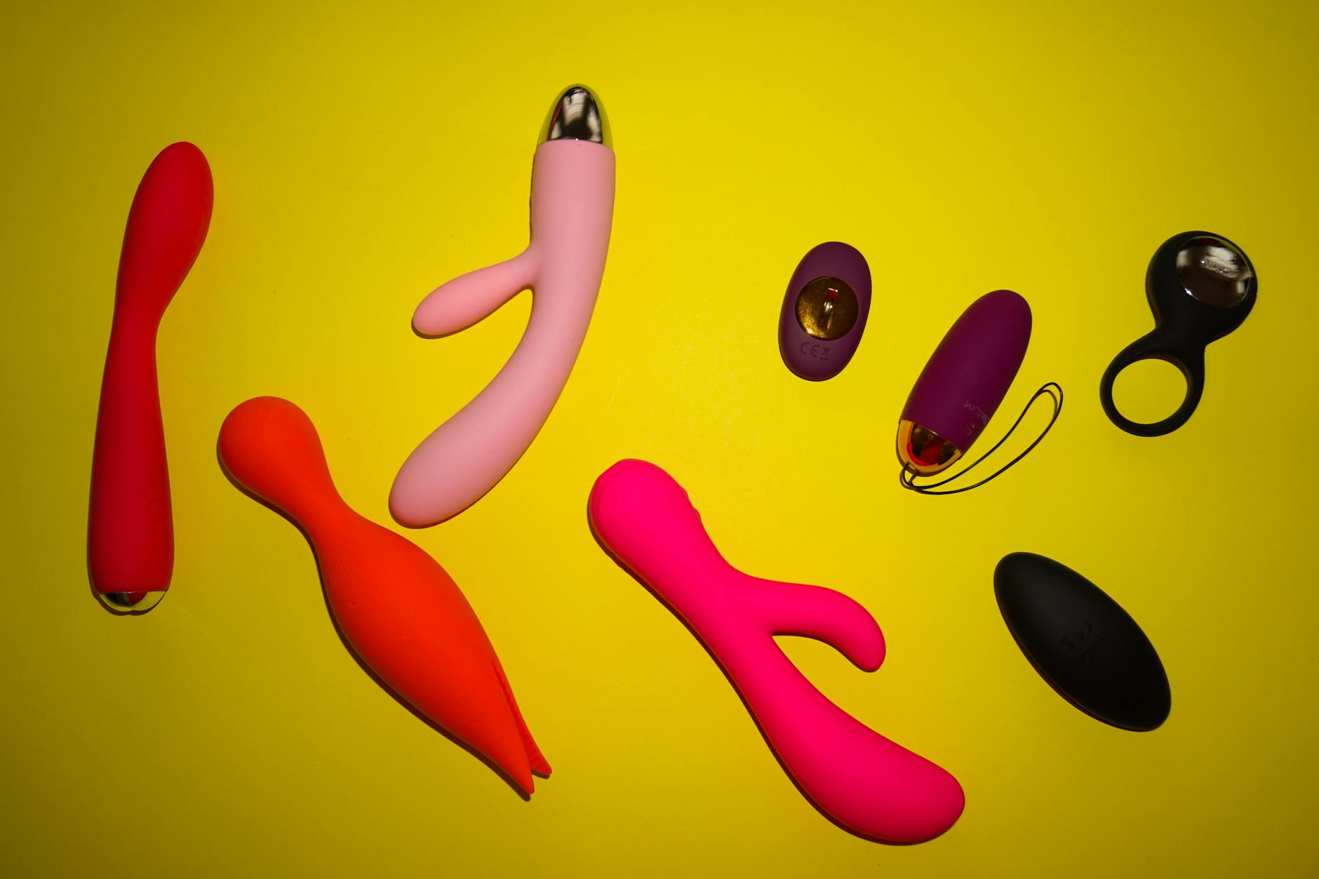 Close-up of hands holding a sleek lemon vibrator against a vibrant background