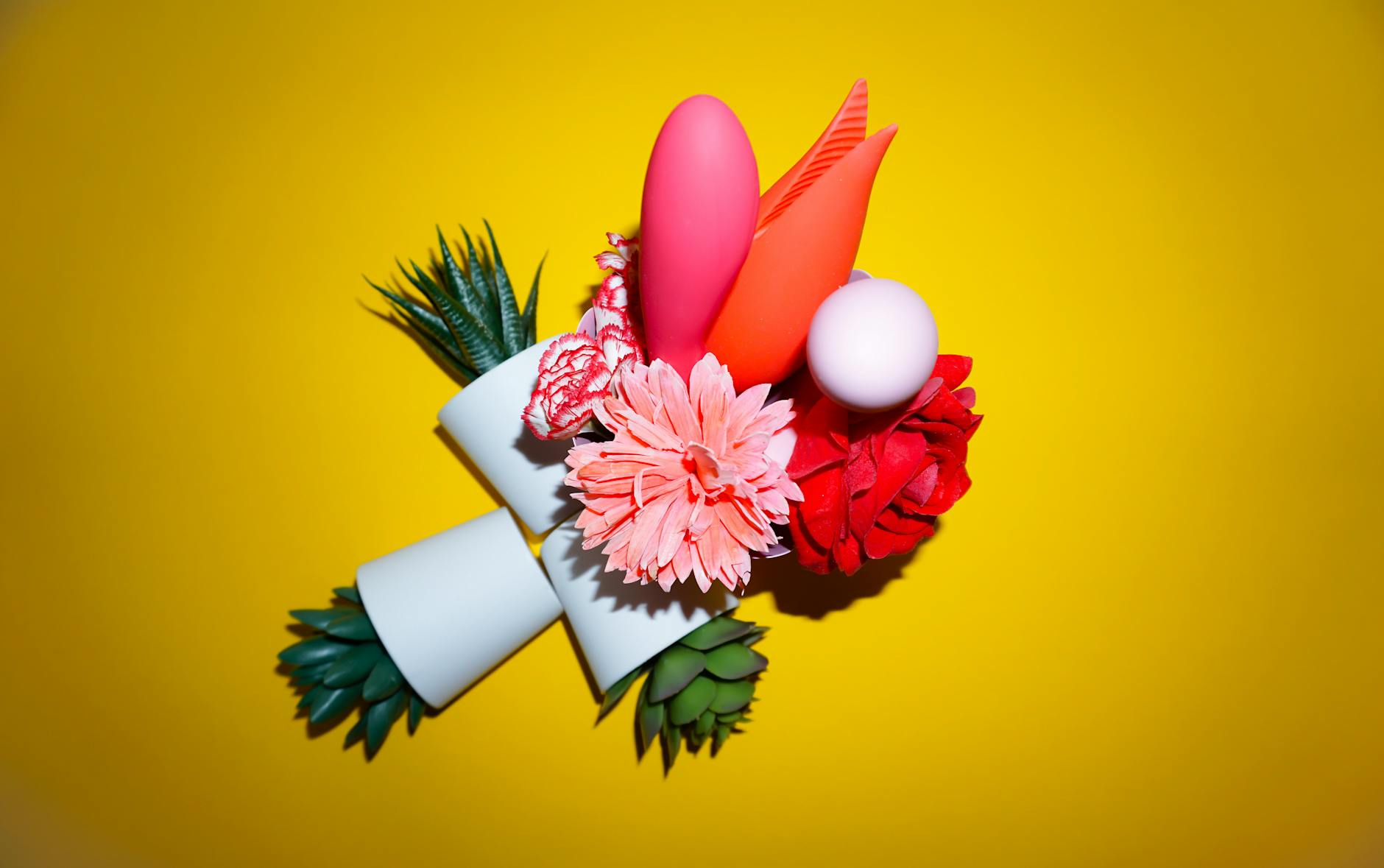 A hand with white nails holding a lemon on a soft pink background, surrounded by three additional lemons.