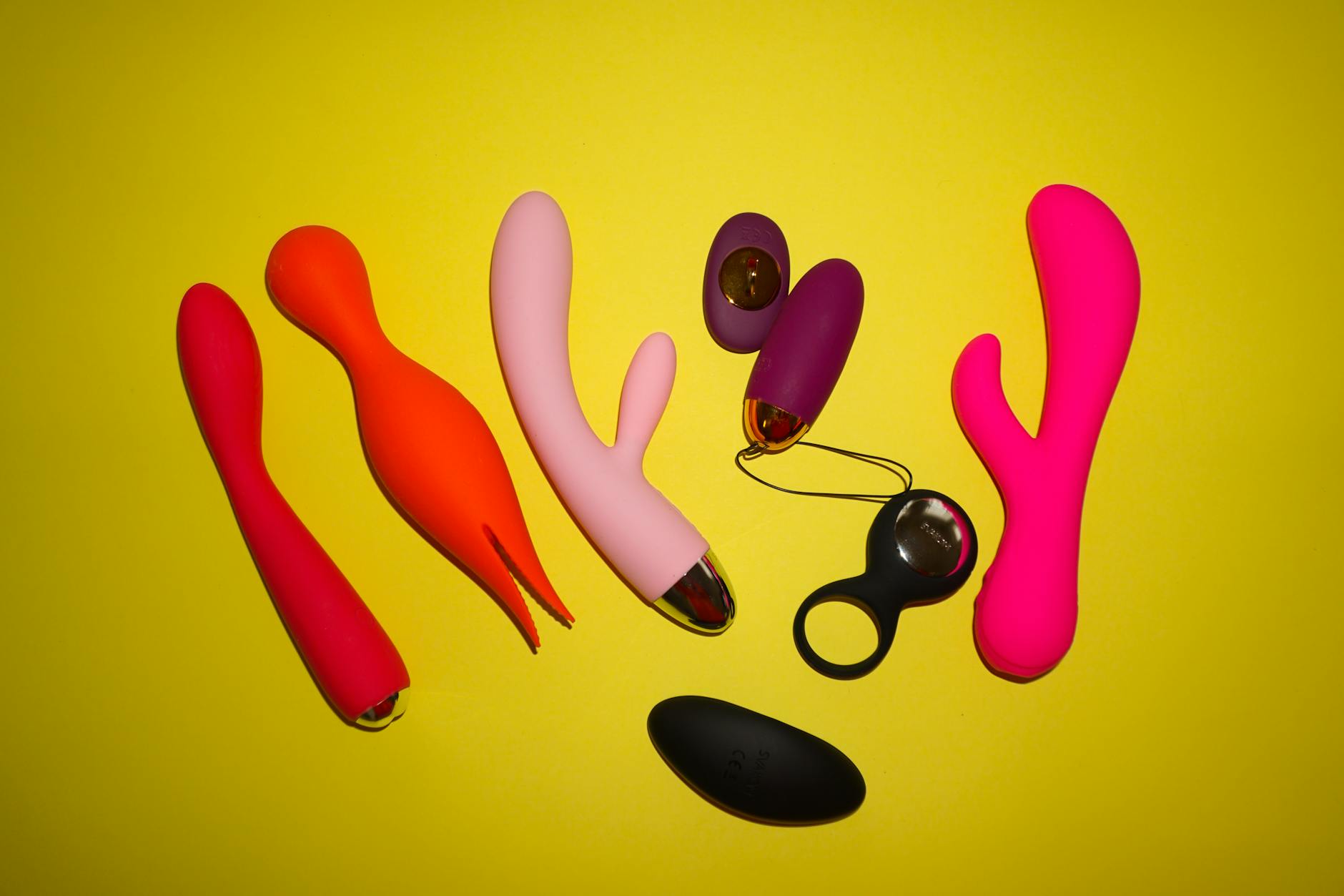 Hands holding a sleek lemon clitoral vibrator against a purple background, representing intimate self-exploration